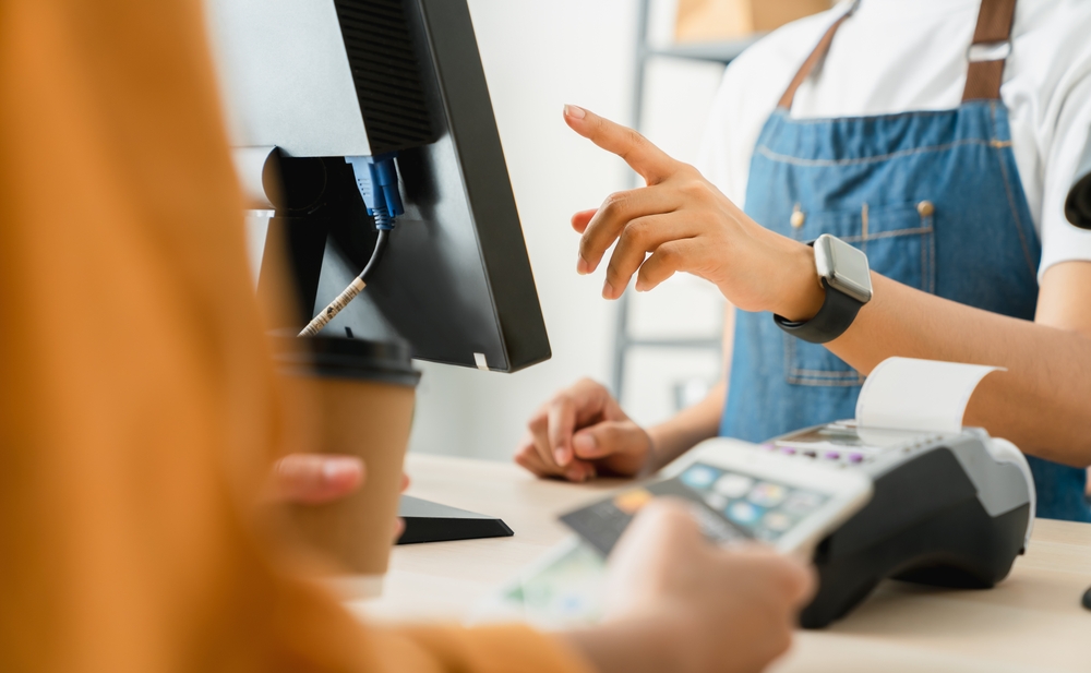 Woman,Cashier,Wears,An,Apron,And,Using,Pos,Terminal,To