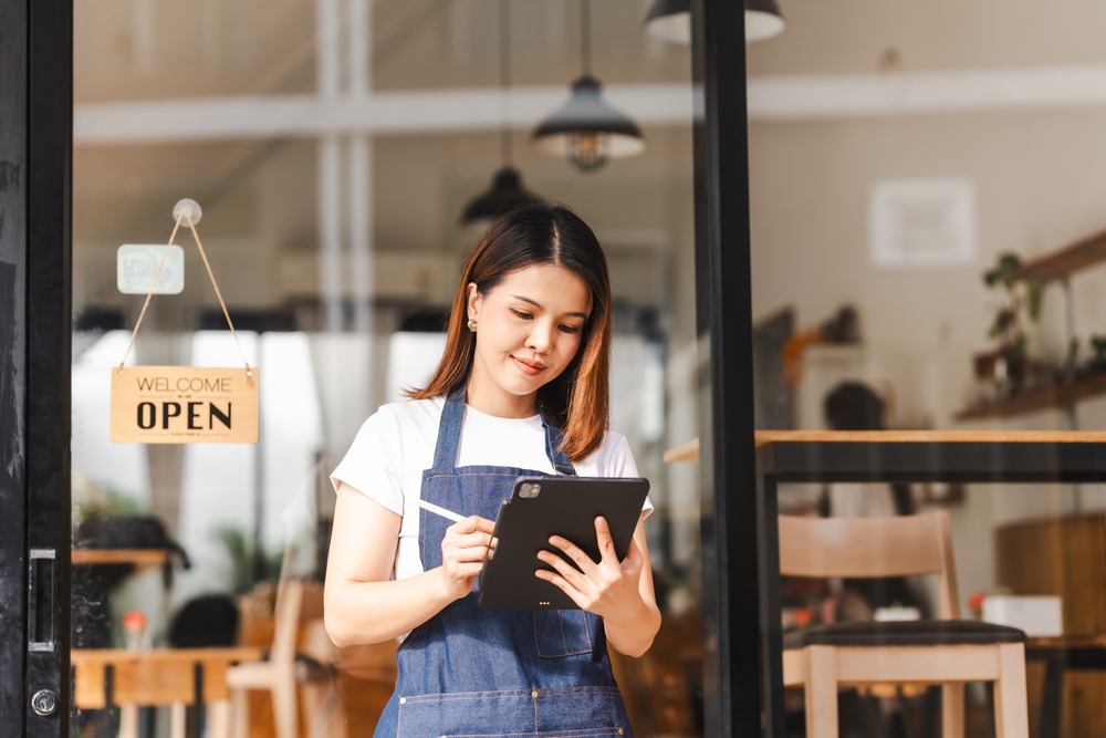 Happy,Excited,Attractive,Young,Asian,Woman,In,Denim,Apron,,Received